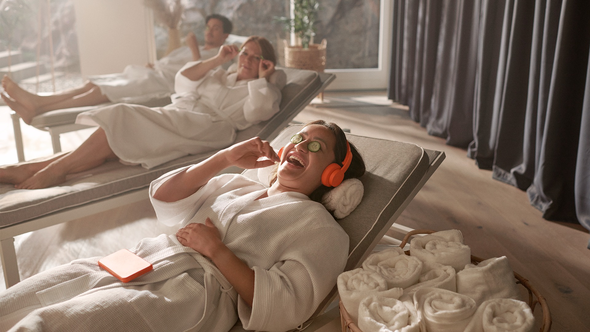 A woman in spa laughing while listening to an audiobook